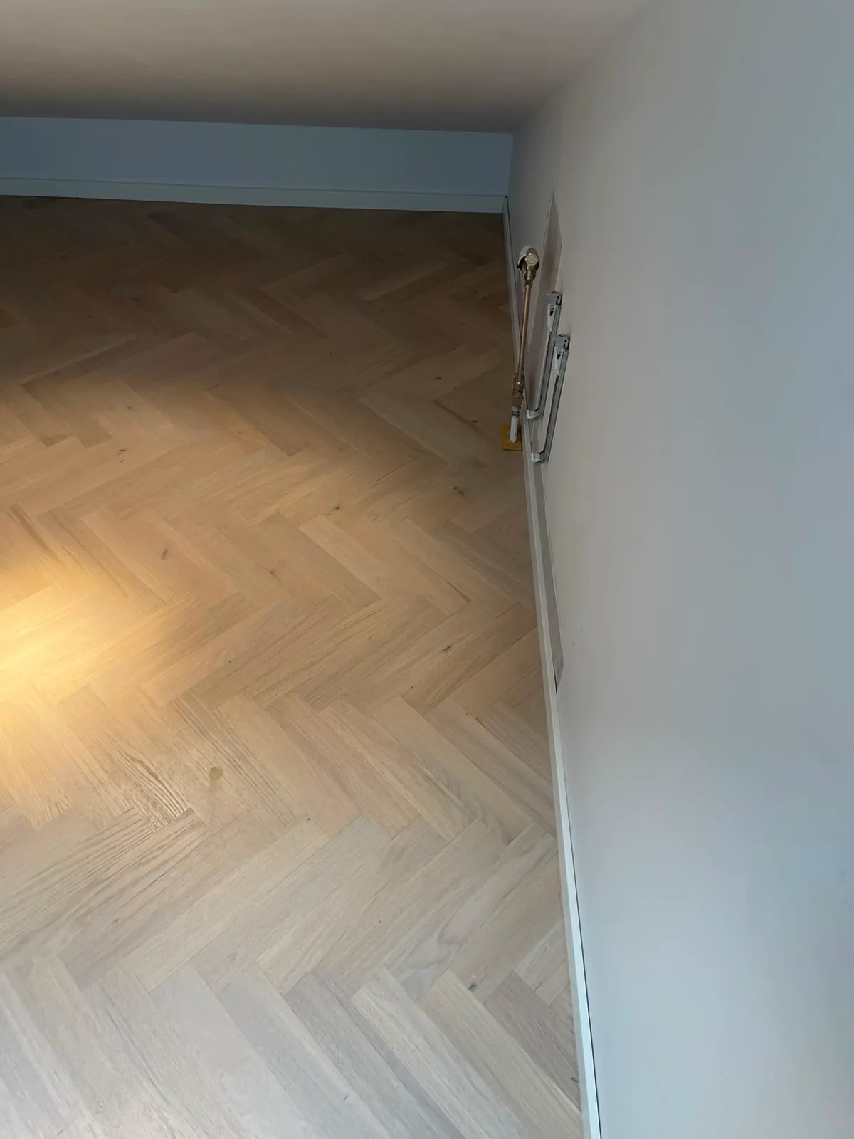 Färdig ljus fiskbensparkett längs snedtaket