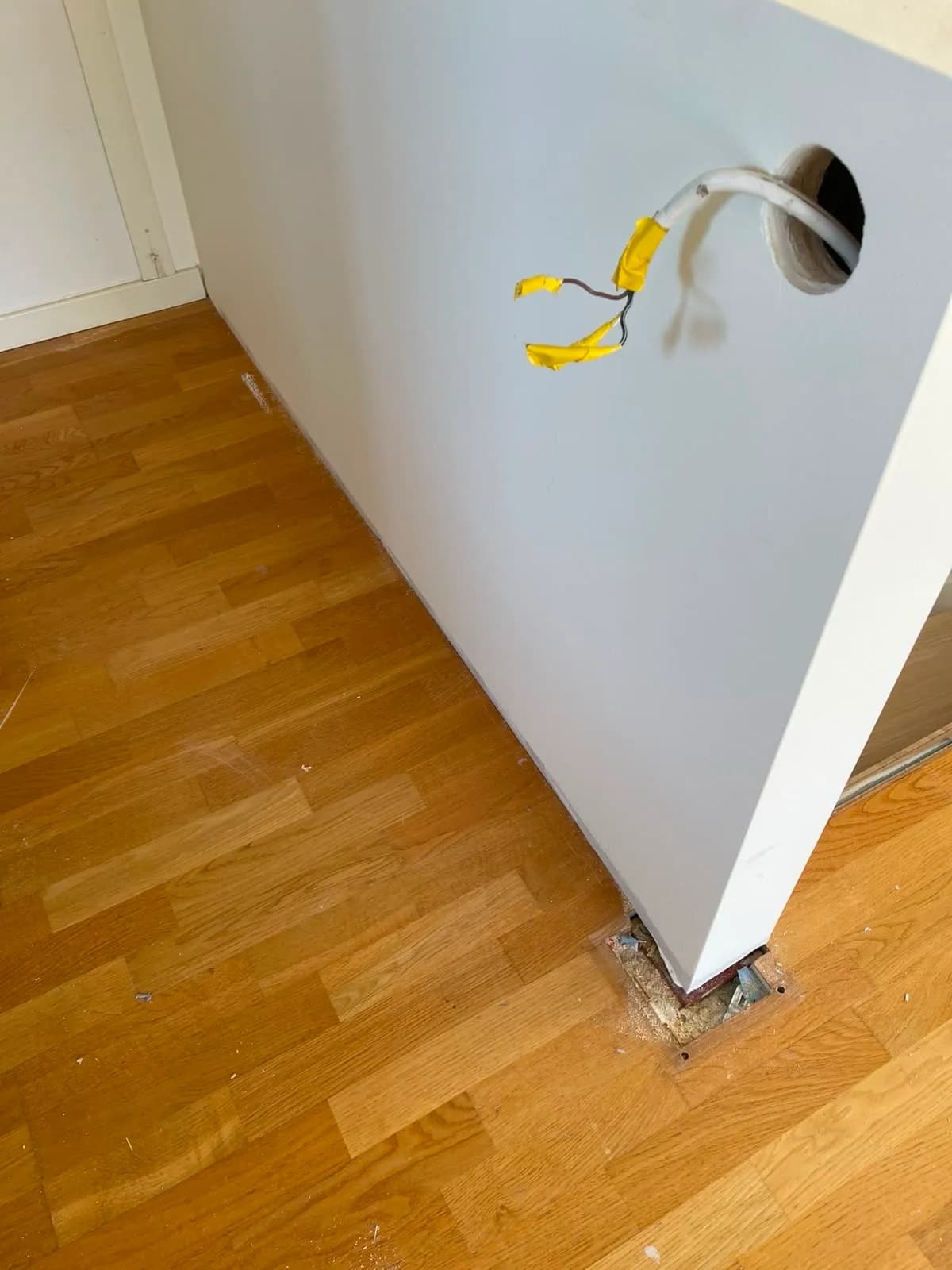 Skadat golv vid väggen innan det byttes