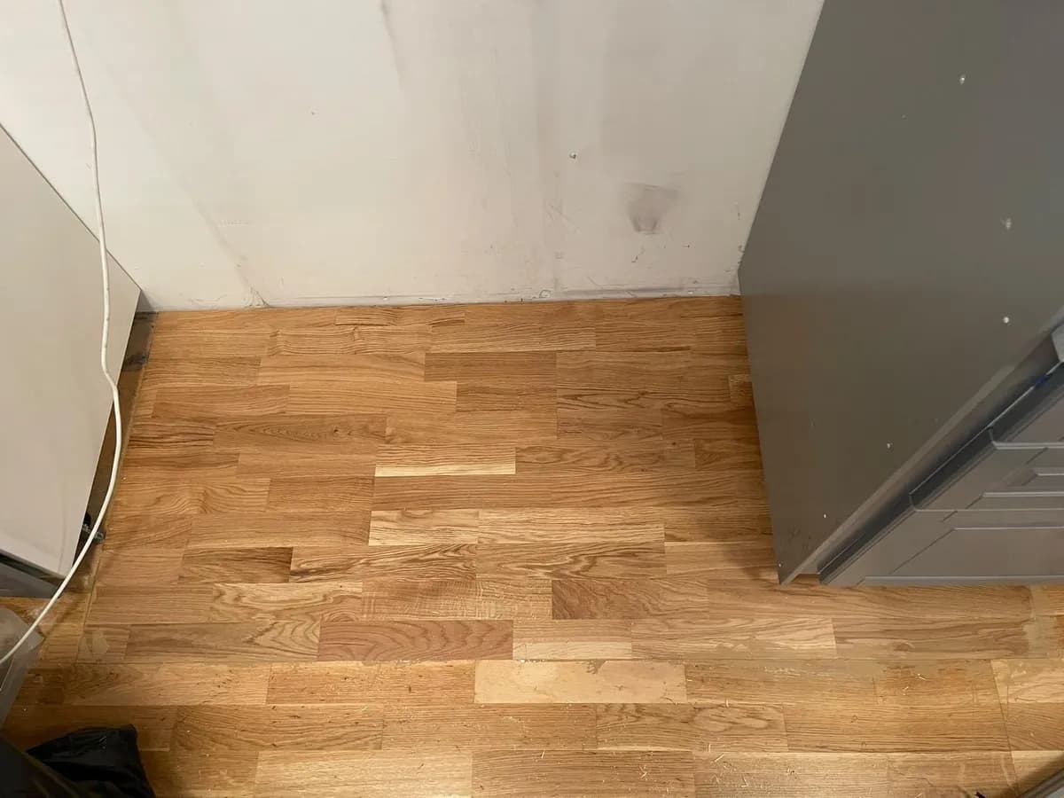 Färdigt golv med ny ekparkett vid köksskåpen